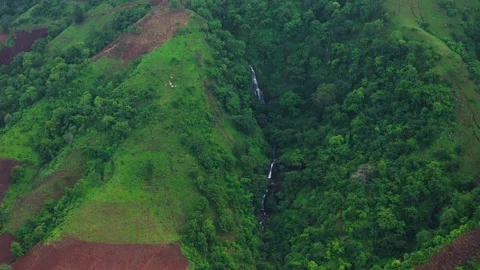 Aerial View of a Small Waterfall in Lush Green Mountains Stock Footage 339682857