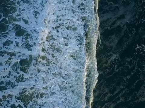 Aerial View of a small wave rolling over the water at the Beach of Juist. Stock Footage