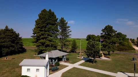 Aerial view of the small white chapel beside pine trees at the geographic center Stock-Footage 345532855