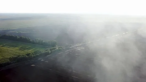 Aerial view of smoke from a fire over a plowed field 스톡 동영상 126169935