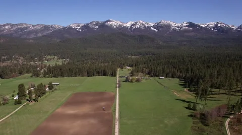 Aerial View of Snow-Capped Mountain Over Lush Farm | Scenic Rural Montana Video stock 65631184