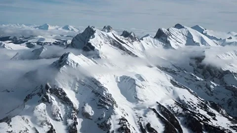 Aerial View of Snow Capped Mountain Peaks with Clouds Rolling Through Dynam.. Stock-Footage 321948180
