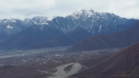 Aerial View of Snow-Capped Mountain Range Over Small Rural Village. A sceni.. Video stock 332004498