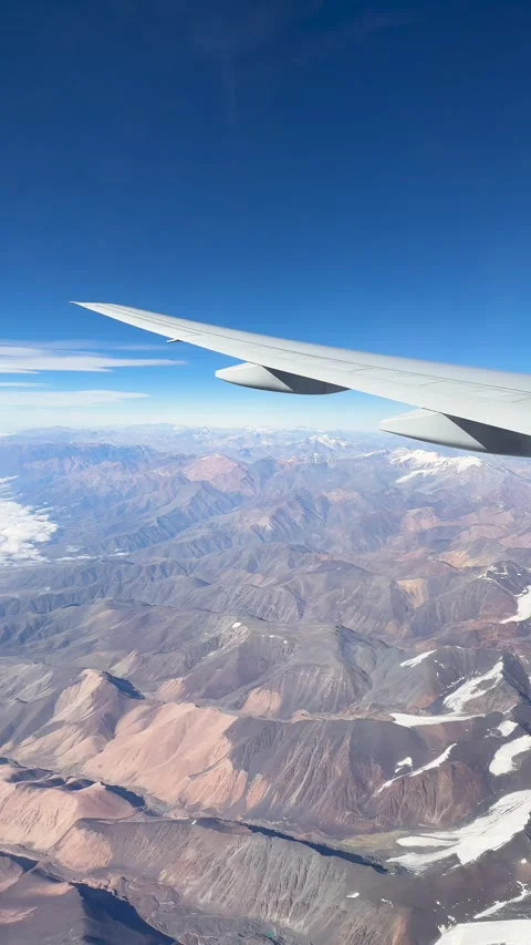 Aerial view of a snow-capped mountain range from an airplane window Stock Footage 333192000