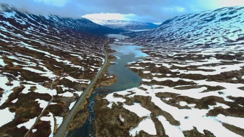 Aerial view of snow capped mountains with river flowing in the middle in norw Stock-Footage 246469972