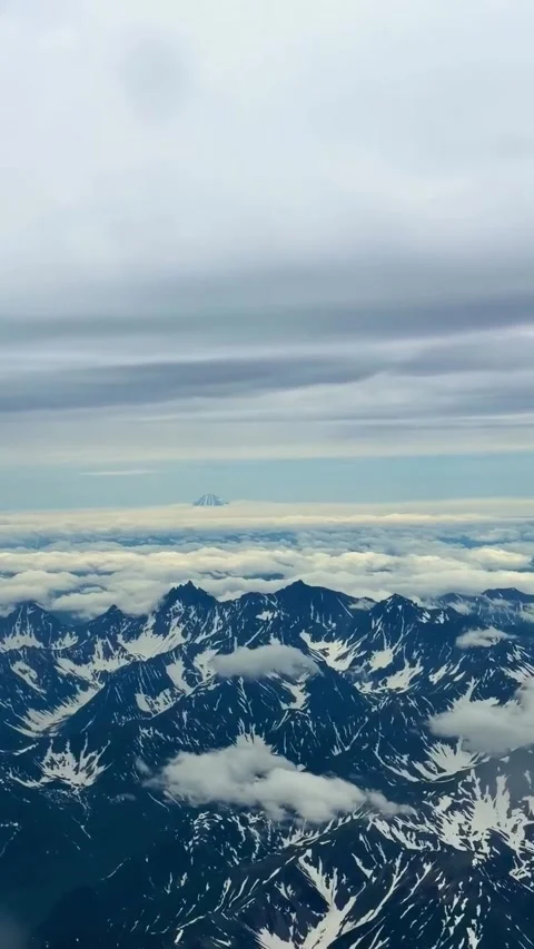 Aerial View of Snow-Capped Mountains and Clouds from Airplane Stock Footage 341133027