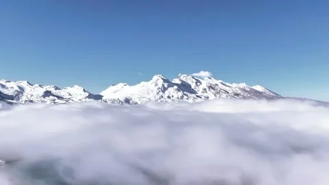 Aerial View of Snow Capped Peaks Rising Above Clouds Under Blue Sky Tibet China Stock Footage 339313517