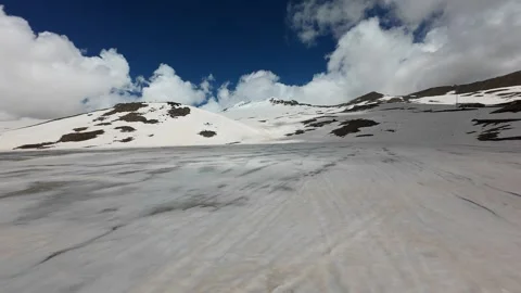 Aerial view of a snow cornice and rocky ridge on Mount Aragats Stock Footage 343876659