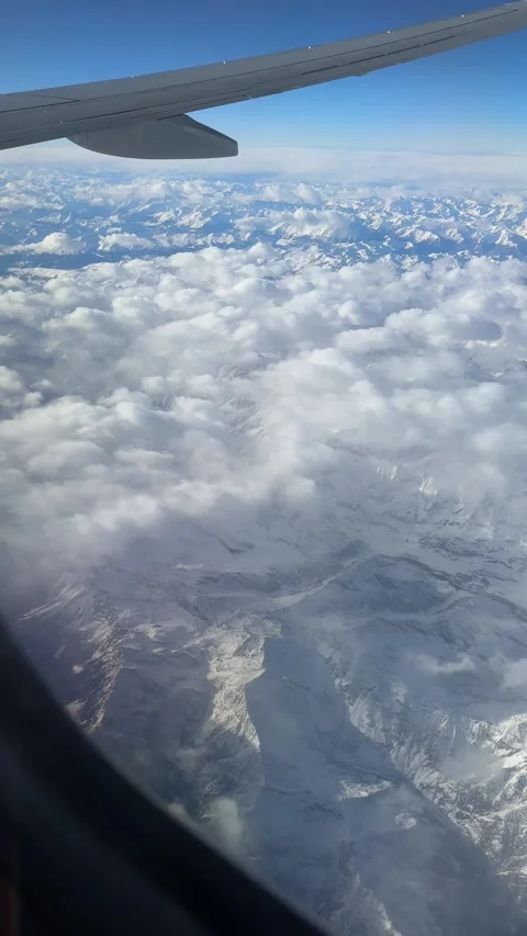 Aerial view of the snow-covered Alps seen through an airplane window Stock Footage 294103138