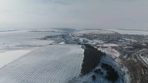 Aerial view of snow-covered fields and rural landscape transitioning from winter Stock Footage 332723897