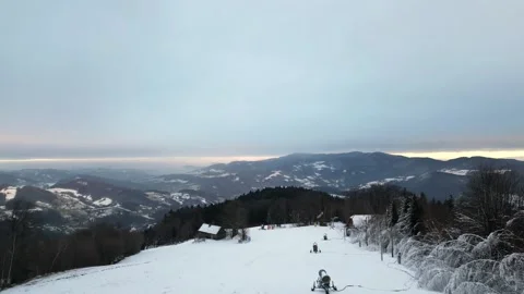 Aerial view of a snow-covered landscape showcasing rolling hills and distant Vidéo 335886161