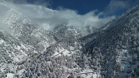Aerial view of a snow covered mountain range in California in winter Stock Footage 263926873