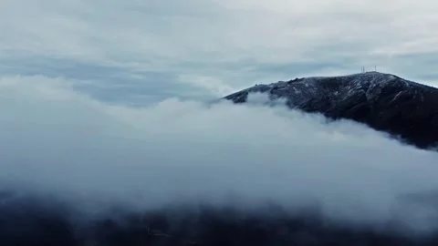 Aerial view of snow covered single peak flat sea of clouds mountain scenery Stock Footage 337925433