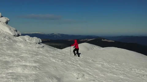 Aerial view of snow mountain range landscape. Climber Walking Up Mountain Exp Stock Footage 165663310