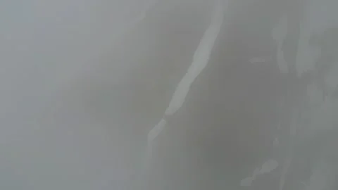 Aerial view of snow patterns through thick fog Stock Footage 345386778