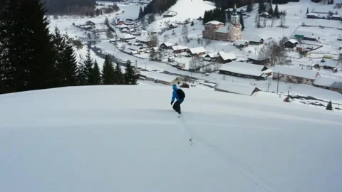 Aerial view of a snowboard that slides down a mountain against the background of Stock Footage 150906413