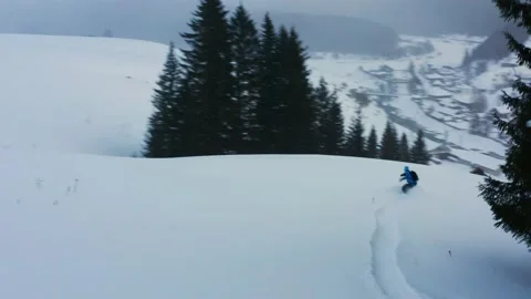 Aerial view of a snowboard that slides down a mountain against the background of Stock Footage 150912558