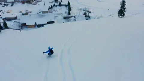 Aerial view of a snowboard that slides down a mountain against the background of Stock Footage 150912681