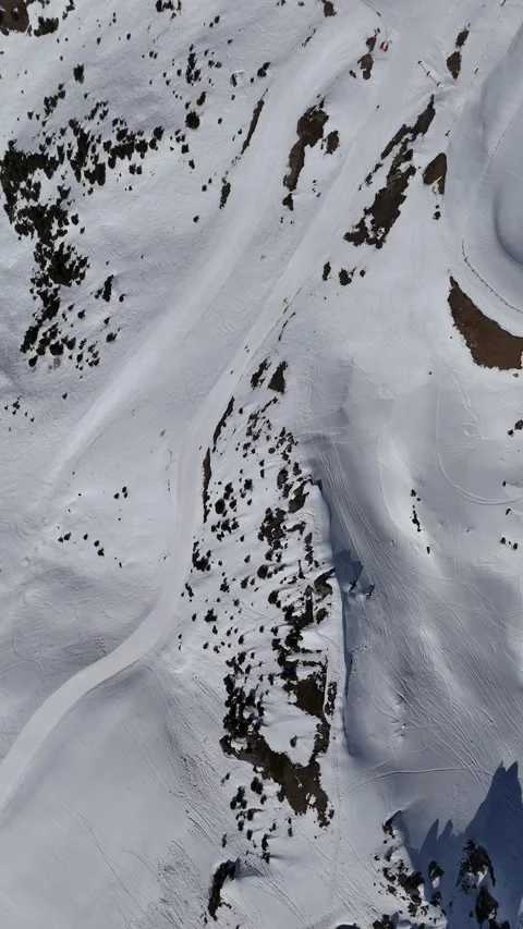 Aerial view of snowcapped mountains by winter, skiers on the slopes Stock Footage 337490801