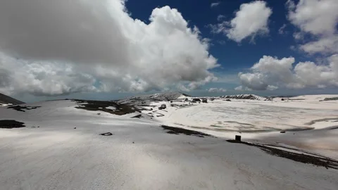 Aerial view of snowfields and cumulus clouds over Mount Aragats Stock Footage 343876354