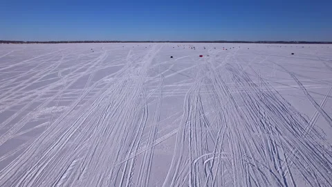 Aerial view of snowmobile and sled or toboggan tracks etched across frozen .. 動画素材 328379727