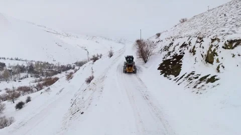 Aerial view of snowplow removing deep snow from mountain road Видео 332368292