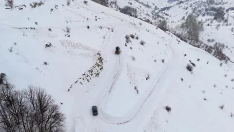 Aerial view of snowplow removing deep snow from mountain road Vidéo 332369441