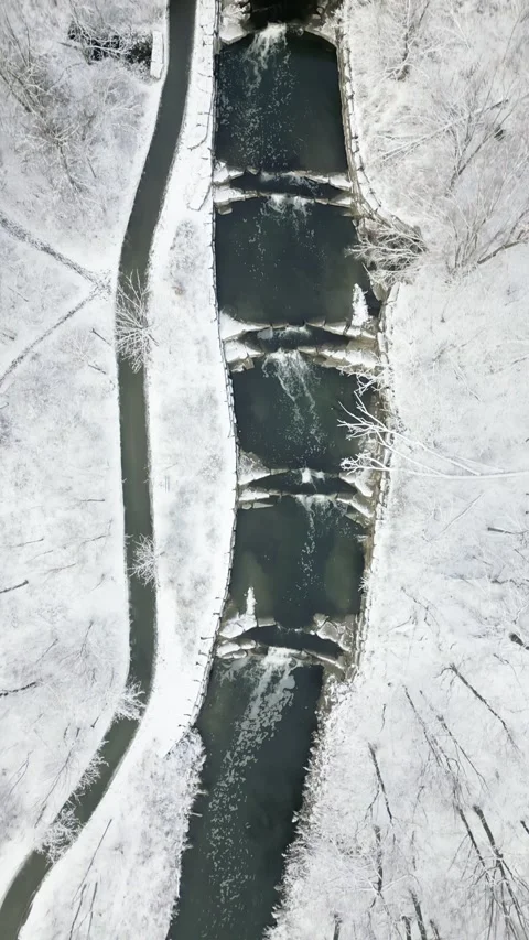 Aerial View of Snowy Bridge Over a Stream in Winter Landscape Stock Footage 293956496