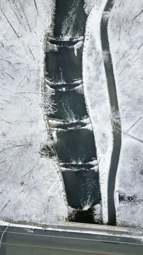 Aerial View of Snowy Bridge Over a Stream in Winter Landscape Stock Footage 293956500