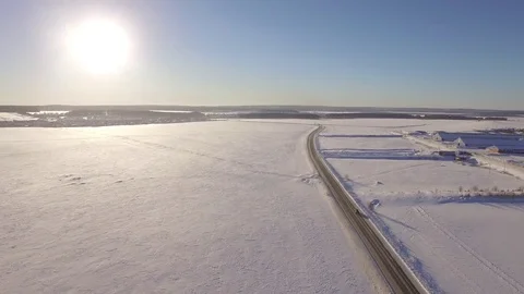 Aerial view of snowy fields and road. SUV driving on winter roads through the Stock Footage