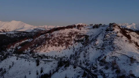 Aerial view of the snowy forest in mountain with the warm sun at sunrise Stock Footage 119557953