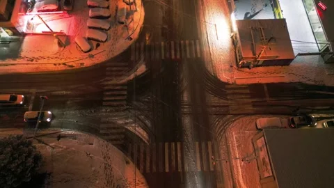 Aerial View of a Snowy Intersection with Moving Cars in Winter Weather Stock Footage 303486579