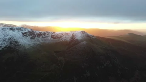 Aerial view of snowy mountain range at sunrise, England Stock Footage 239432453