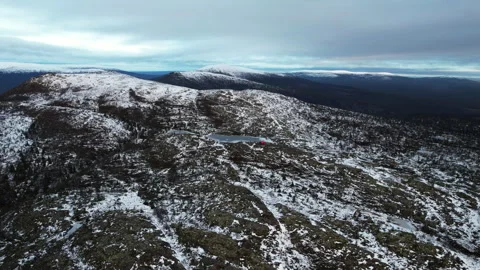 An aerial view of a snowy mountain range with a lake in the middle Vidéo 264859897