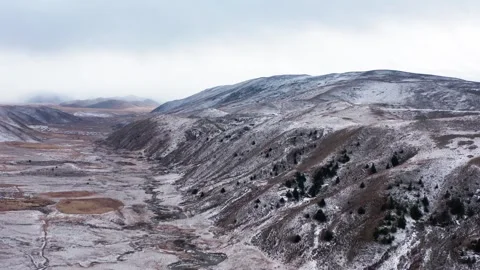 Aerial view of snowy mountain range and winding river in winter landscape Stock Footage 342095535