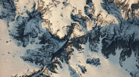 Aerial view of a snowy mountain range, with a winding road. View from above.  Ilustração Stock