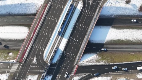 Aerial view of snowy road intersection with multiple lanes, vehicles in motion Stock-Footage 328294485