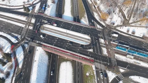 Aerial view of snowy road intersection with multiple lanes, vehicles in motion Video stock 347789038