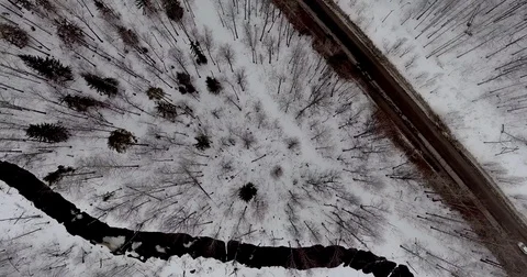 Aerial view of snowy trees, winter road and a black river water. Stock Footage 73672734