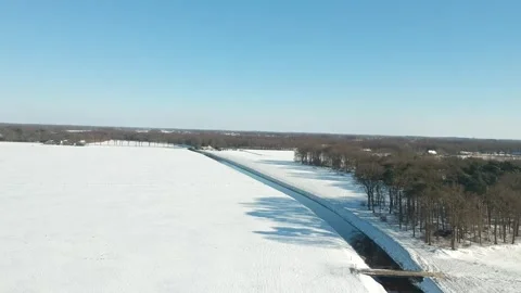 Aerial View of a Snowy Winter Landscape with Bridge and Ditch, the Netherlan Stock Footage 339736737