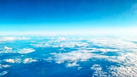 Aerial view of soft cloud layers seen from high flying commercial airplane wi Stock Photos