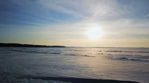 Aerial view of soft sunset over frozen lake covered with ice and snow. Beautiful Stock Footage 87189222