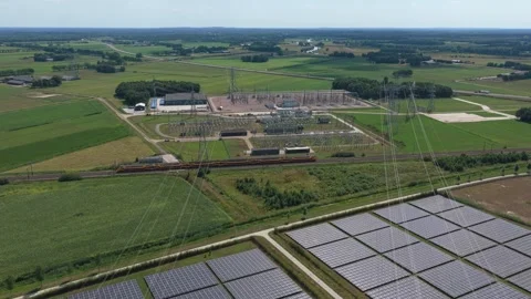 Aerial view of solar farm, electrical substation, and freight train Stockbeeldmateriaal 341874927