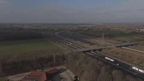 Aerial view of solar farm with freight train on railway besides highway NL Видео 330189802