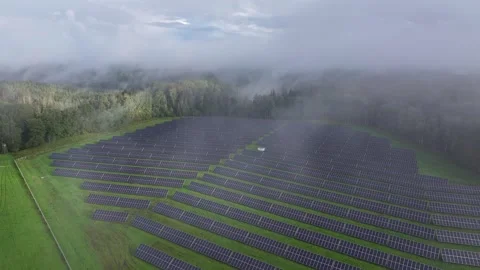 Aerial View of Solar Farm Surrounded by Forest and Morning Mist in Latvia Stockbeeldmateriaal 345155601