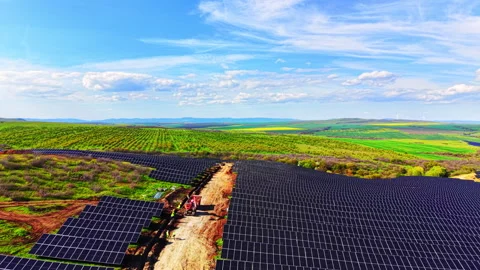 Aerial view of solar panel array reaching distant hills Vídeo Stock 345154423