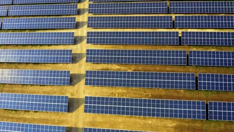 Aerial view of a solar panel farm with rows of panels drawing energy from the Stock Footage 147405594