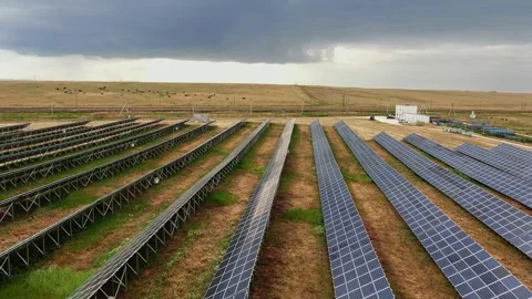 An aerial view of a solar panel farm looking towards the horizon with a mountain 스톡 동영상 258329558