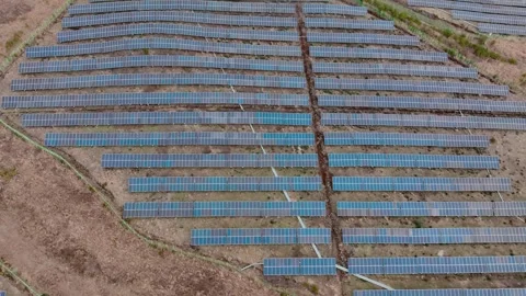 Aerial view of solar panels and wind turbines in Jeju Island Stock Footage 296420488