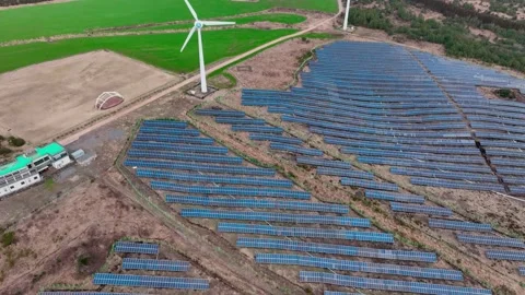 Aerial view of solar panels and wind turbines in Jeju Island Stock Footage 296439205